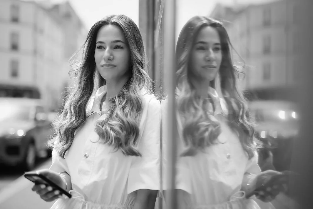Reflet en noir et blanc d'une chevelure ondulée de perruque naturelle dans le miroir du salon