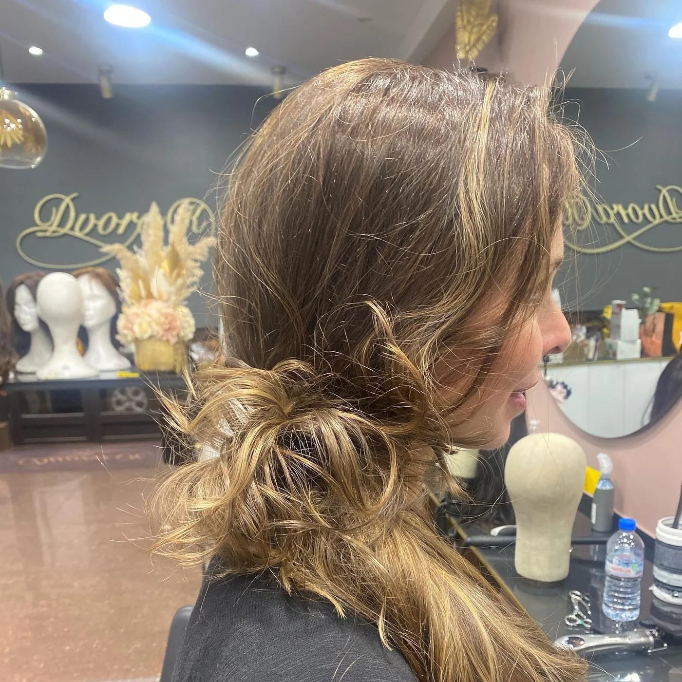 Chignon bas flou réalisé sur une perruque en cheveux naturels, vue latérale