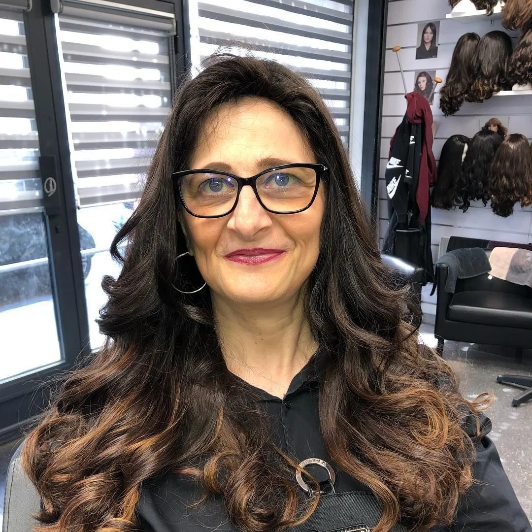 Perruque longue ondulée avec frange portée avec des lunettes par une femme mûre, Dvora K