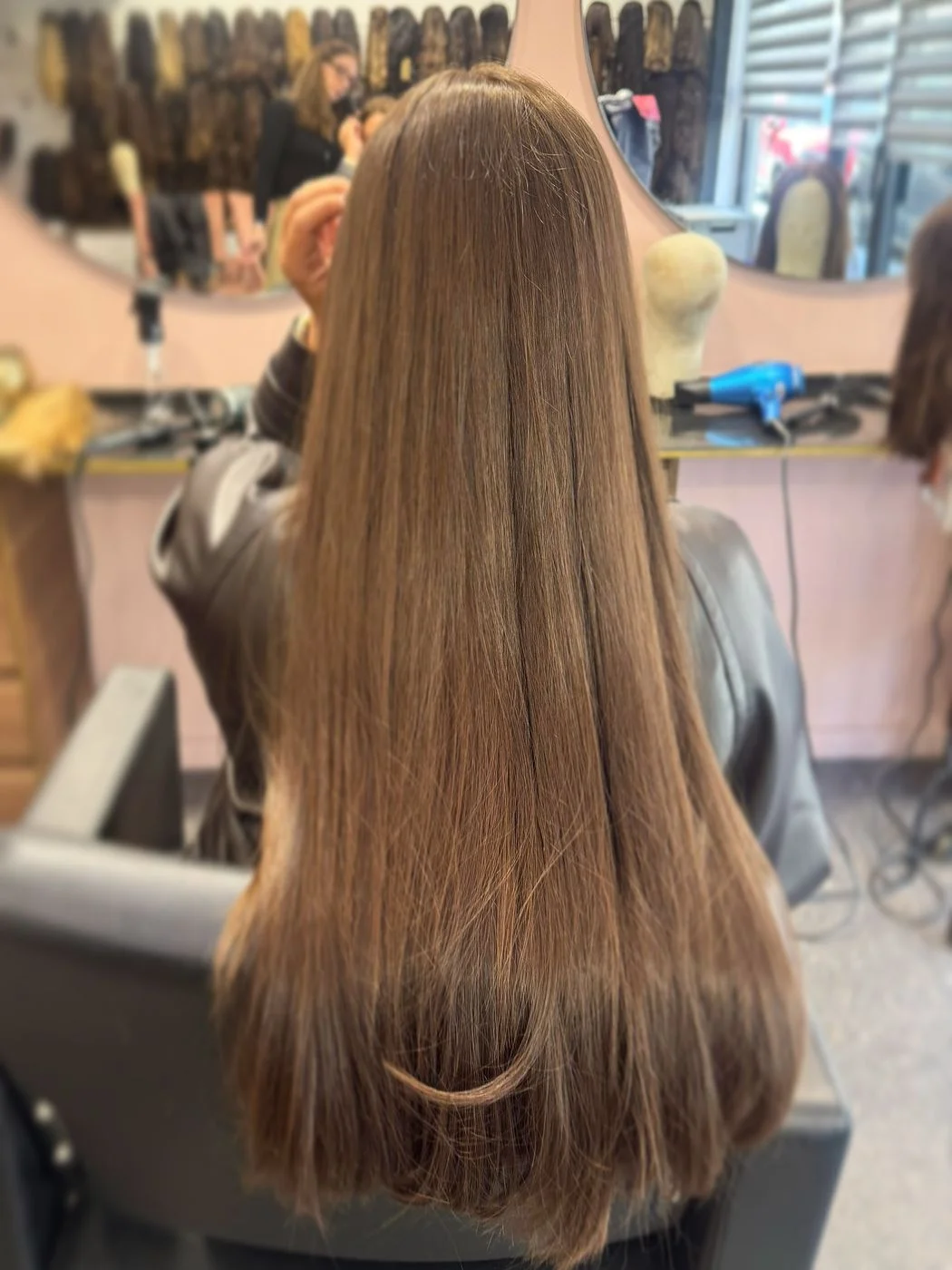 Longueurs lisses et brillantes d'une perruque naturelle, dans le sens des cheveux