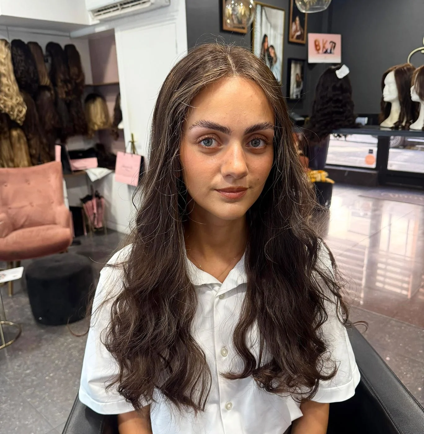 Perruque longue brune ondulée en cheveux naturels, portée avec une chemise blanche, Dvora K