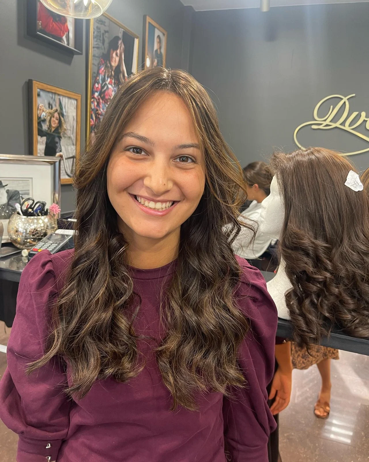 Cliente au salon à côté d'une perruque en cheveux naturels montée sur tête à perruque