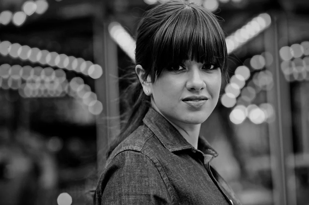 Portrait en noir et blanc d'une femme portant une perruque à frange épaisse, attachée en queue de cheval
