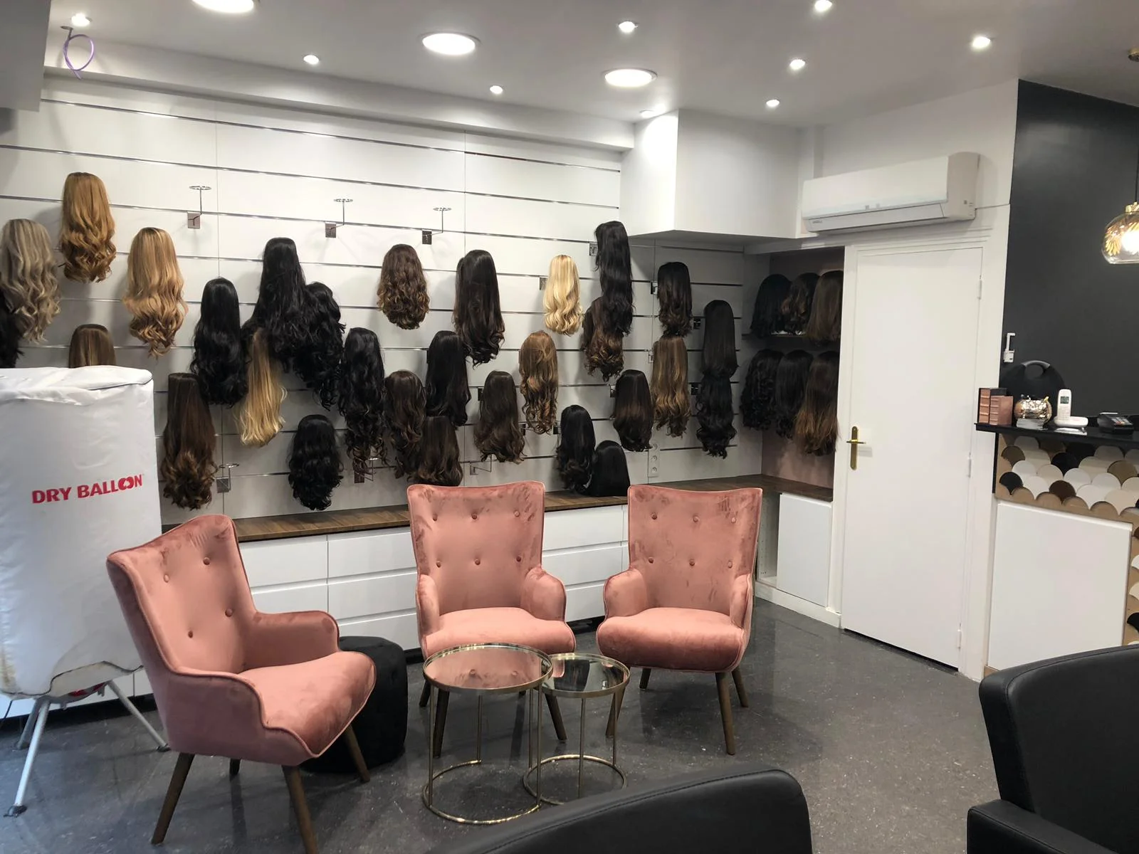 Le salon Dvora K à Paris 19e : mur de perruques en cheveux naturels et fauteuils d'essayage