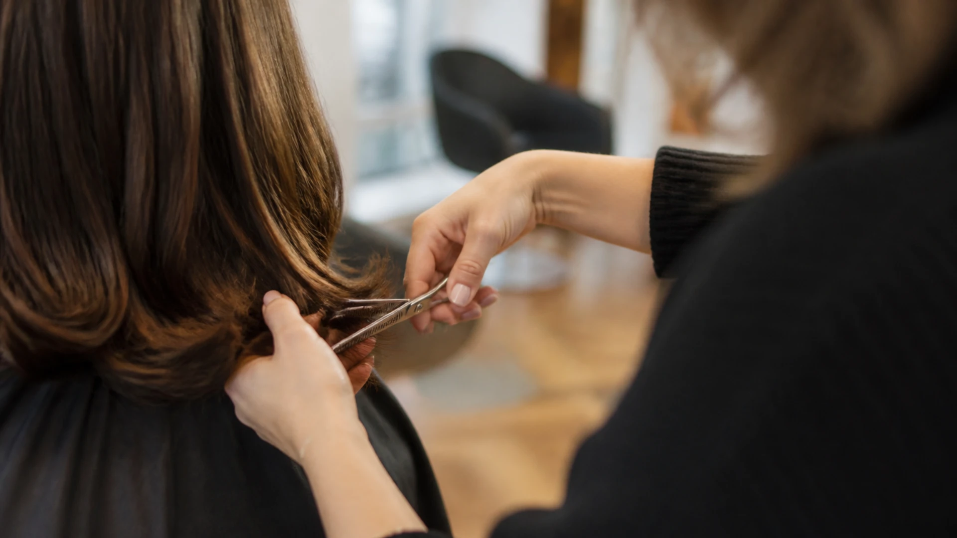 Désépaississement d'une perruque aux ciseaux sculpteurs, portée sur la tête de la cliente au salon