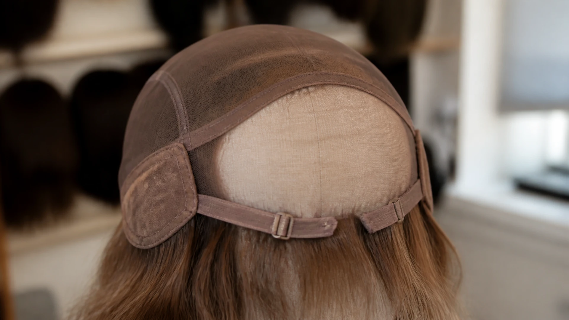 Intérieur du bonnet d'une perruque avec ses brides de réglage et ses pattes devant les oreilles