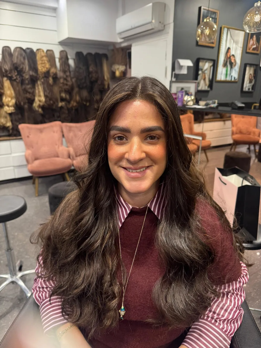 Cliente du salon avec une perruque longue brune ondulée en cheveux naturels