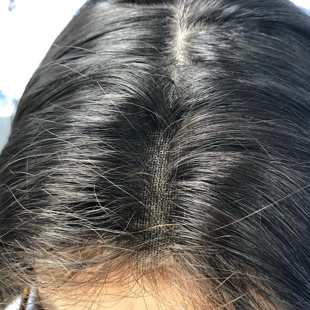 Gros plan sur la raie d'une perruque à base lace, brun foncé
